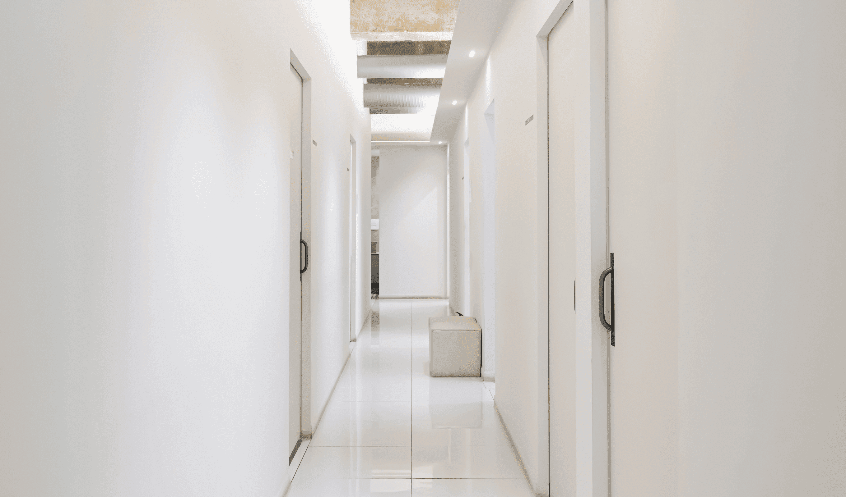 진료실로 이어지는 복도, 환자의 프라이버시 보호와 심리적 안정을 고려한 차분한 화이트 톤 설계